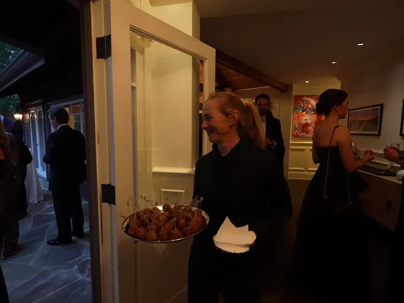 Dinner buffet staffed by servers at an evening event in San Mateo