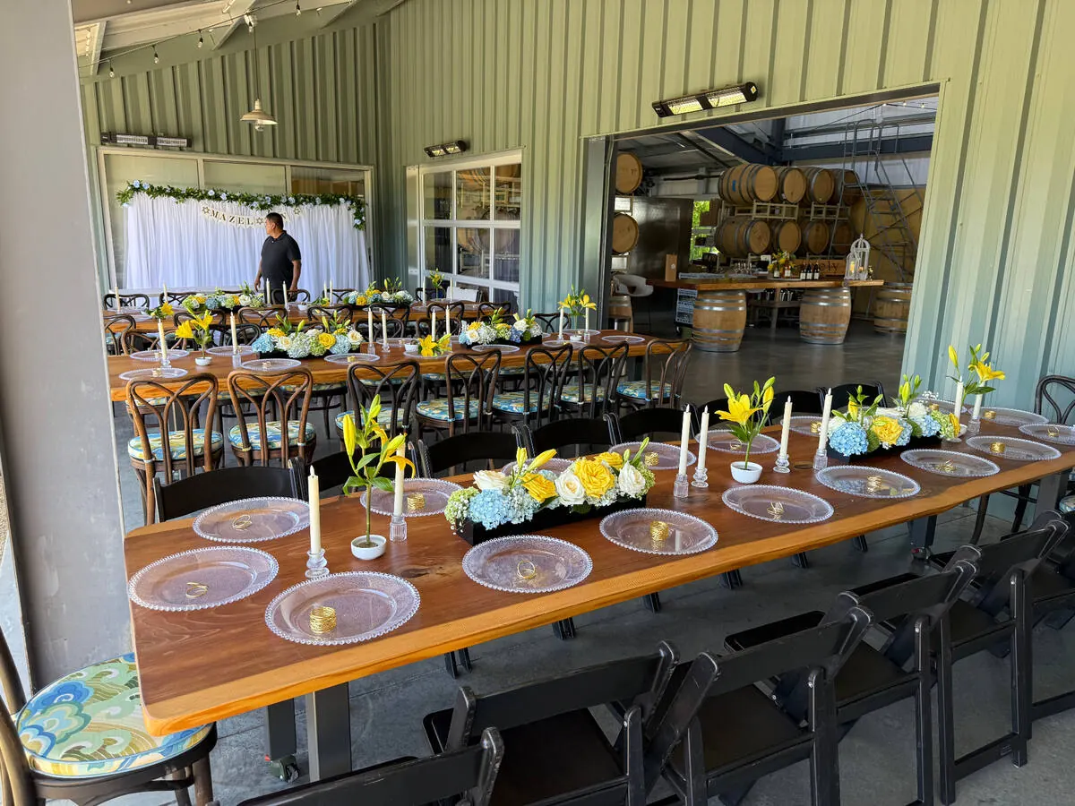 In-house floral centerpieces of garden roses and greenery running down a long dinner table at a Redwood City event by Winslow's Catering Redwood City