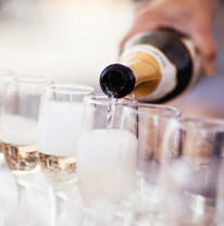 Pouring white wine in a glass for bottle service catering