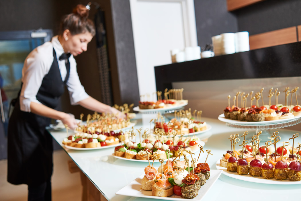 Server arranging the pastries on a buffet table for Redwood City caterers